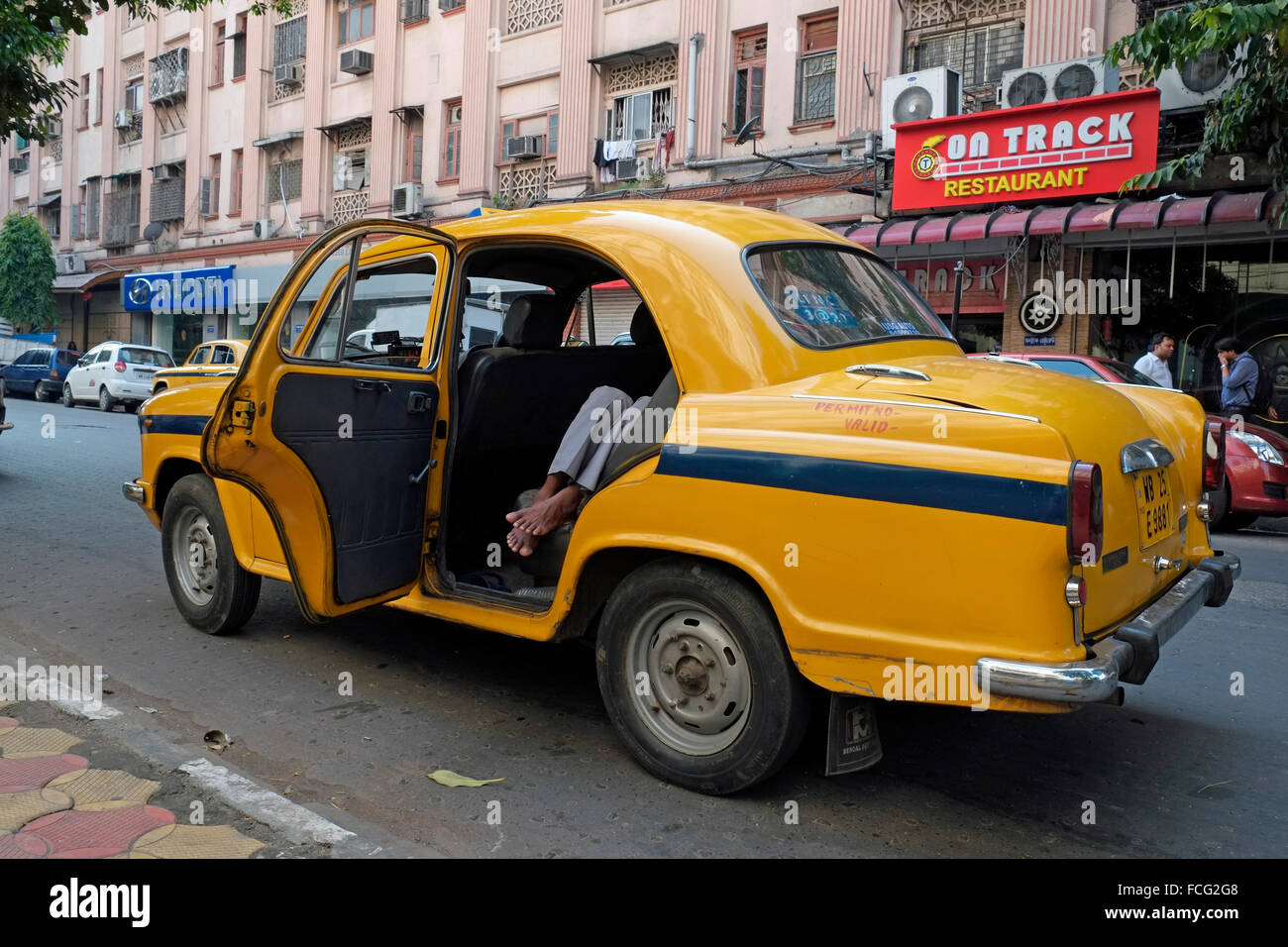 A Hindustan Ambassador taxi with driver sleeping on back seat, Kolkata (Calcutta), West Bengal, India. Stock Photo