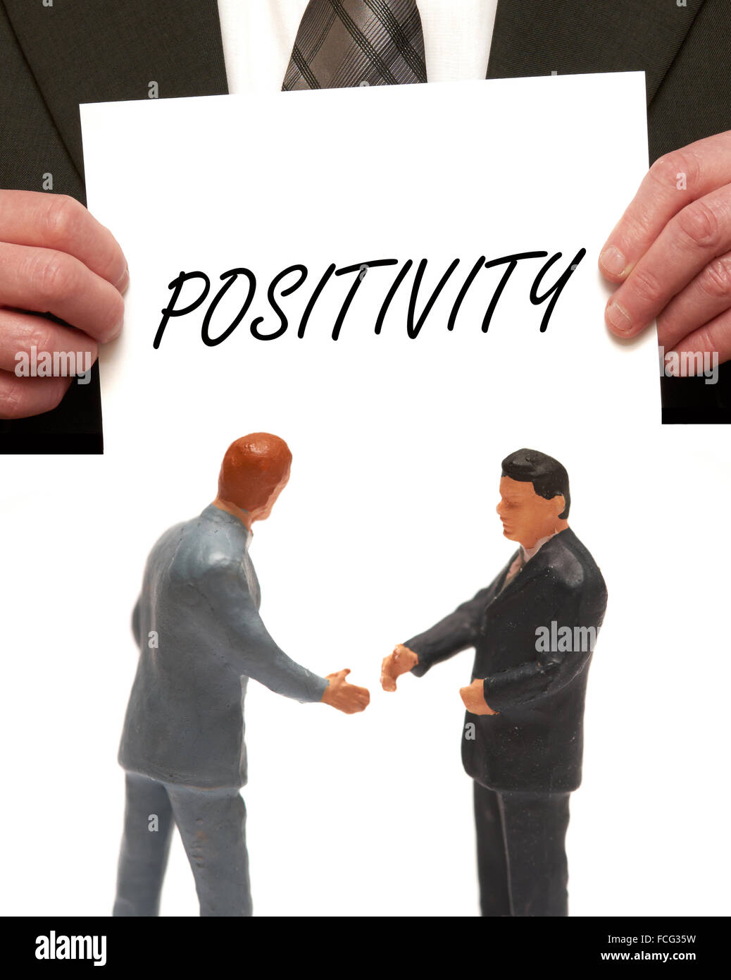 Positivity concept 2 miniature figurines in suits shaking hands Stock Photo
