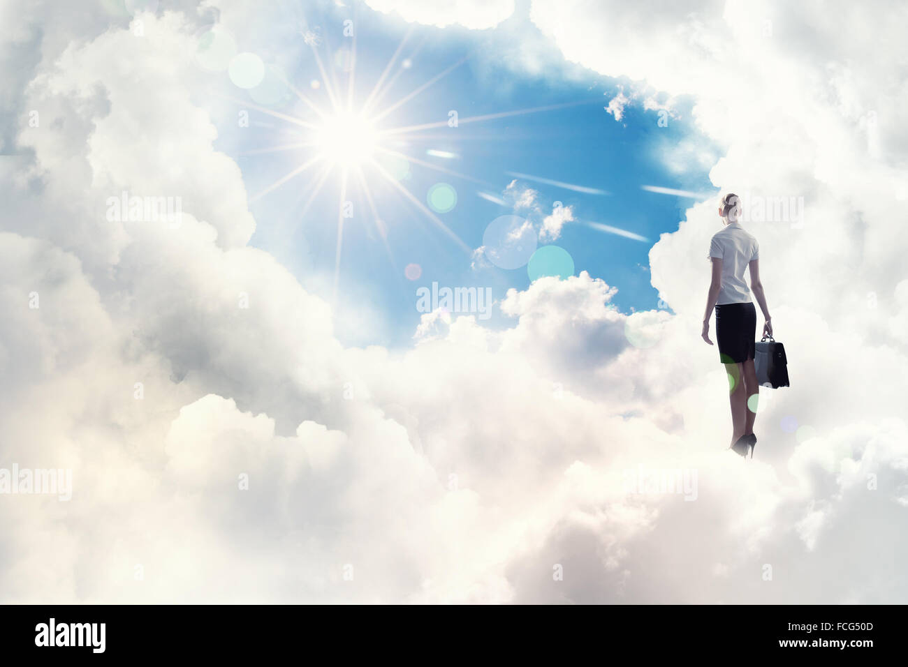 Back view of businesswoman standing on cloud high in sky Stock Photo ...