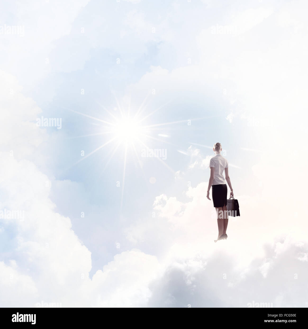 Back view of businesswoman standing on cloud high in sky Stock Photo ...