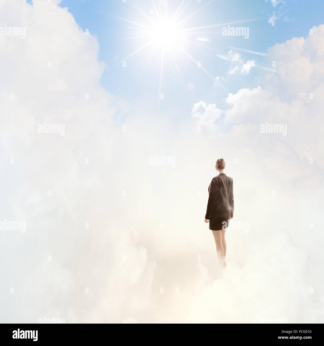 Back view of businesswoman standing on cloud high in sky Stock Photo ...