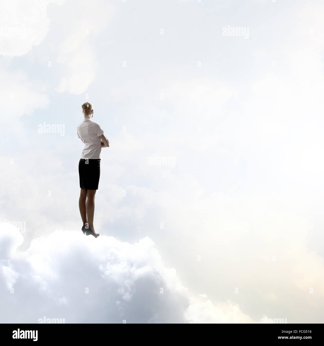 Back view of businesswoman standing on cloud high in sky Stock Photo ...
