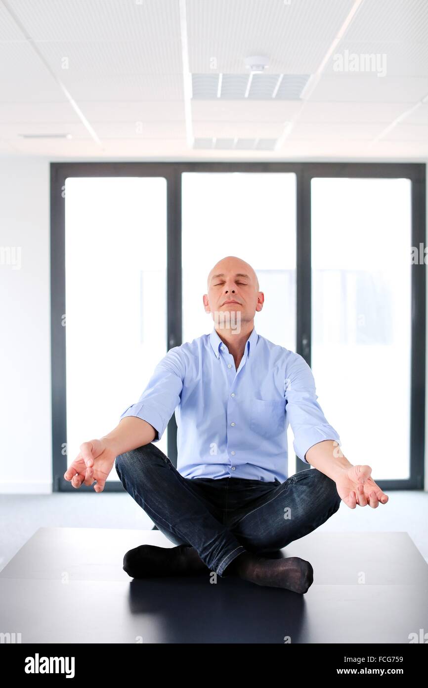 Executive doing Yoga. Empty office. Meeting room Stock Photo Alamy