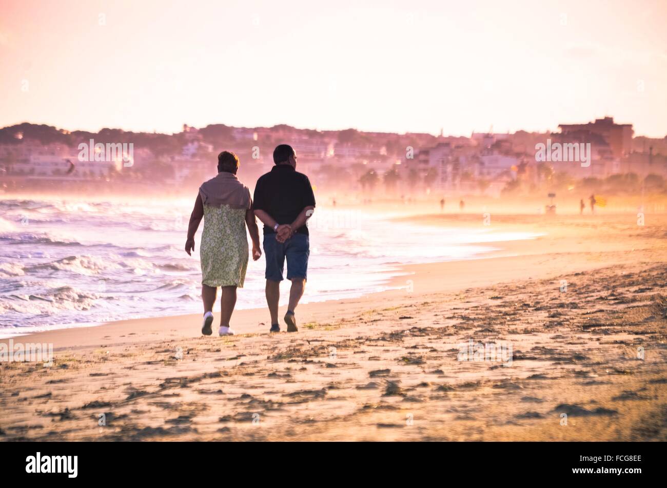 Couple on the beach walking back. Costa Daurada, Costa Dorada, Catalonia, Spain. Stock Photo