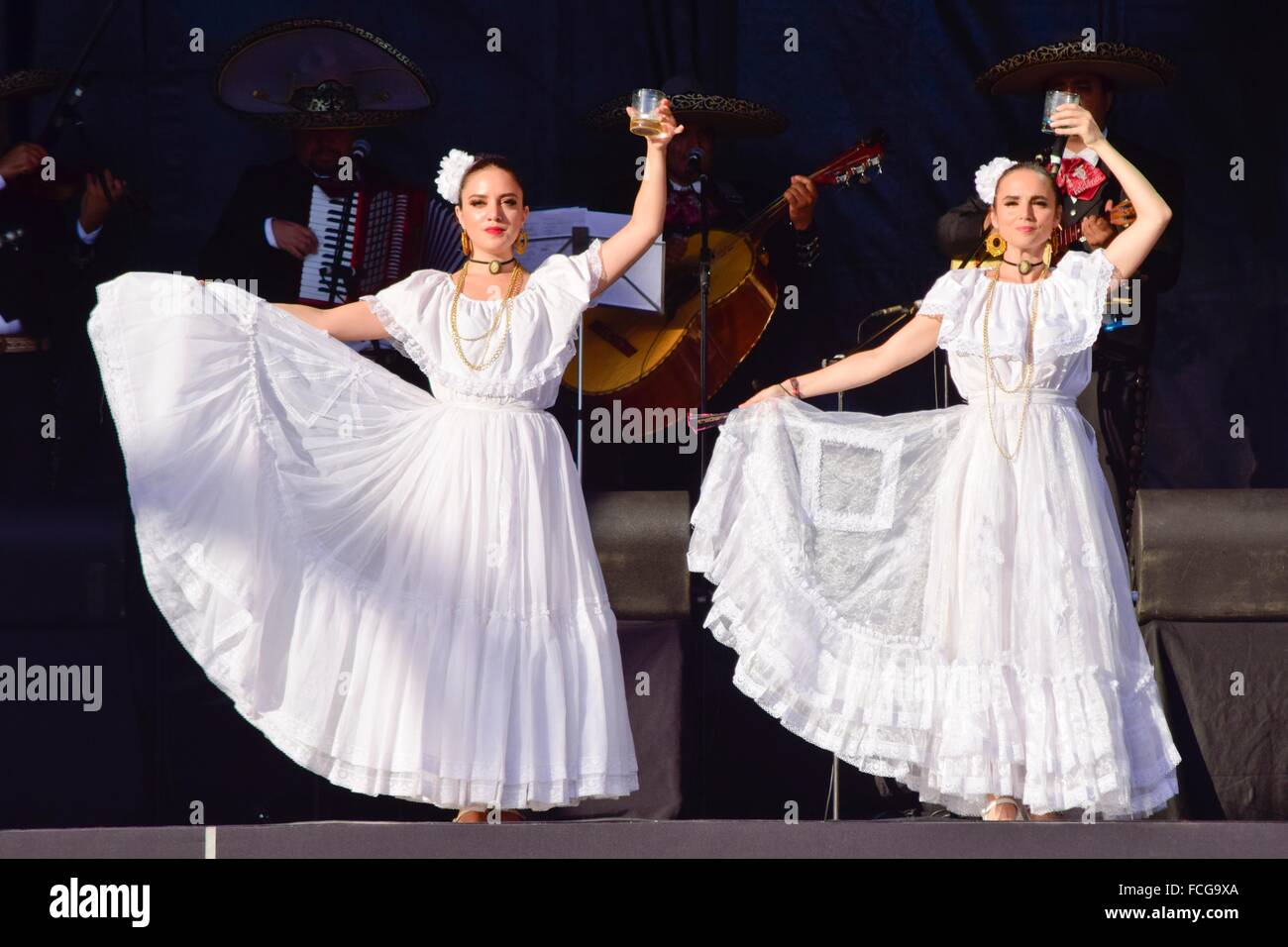 Women are dancing a folk dance of Mexico. The dancers wear traditional