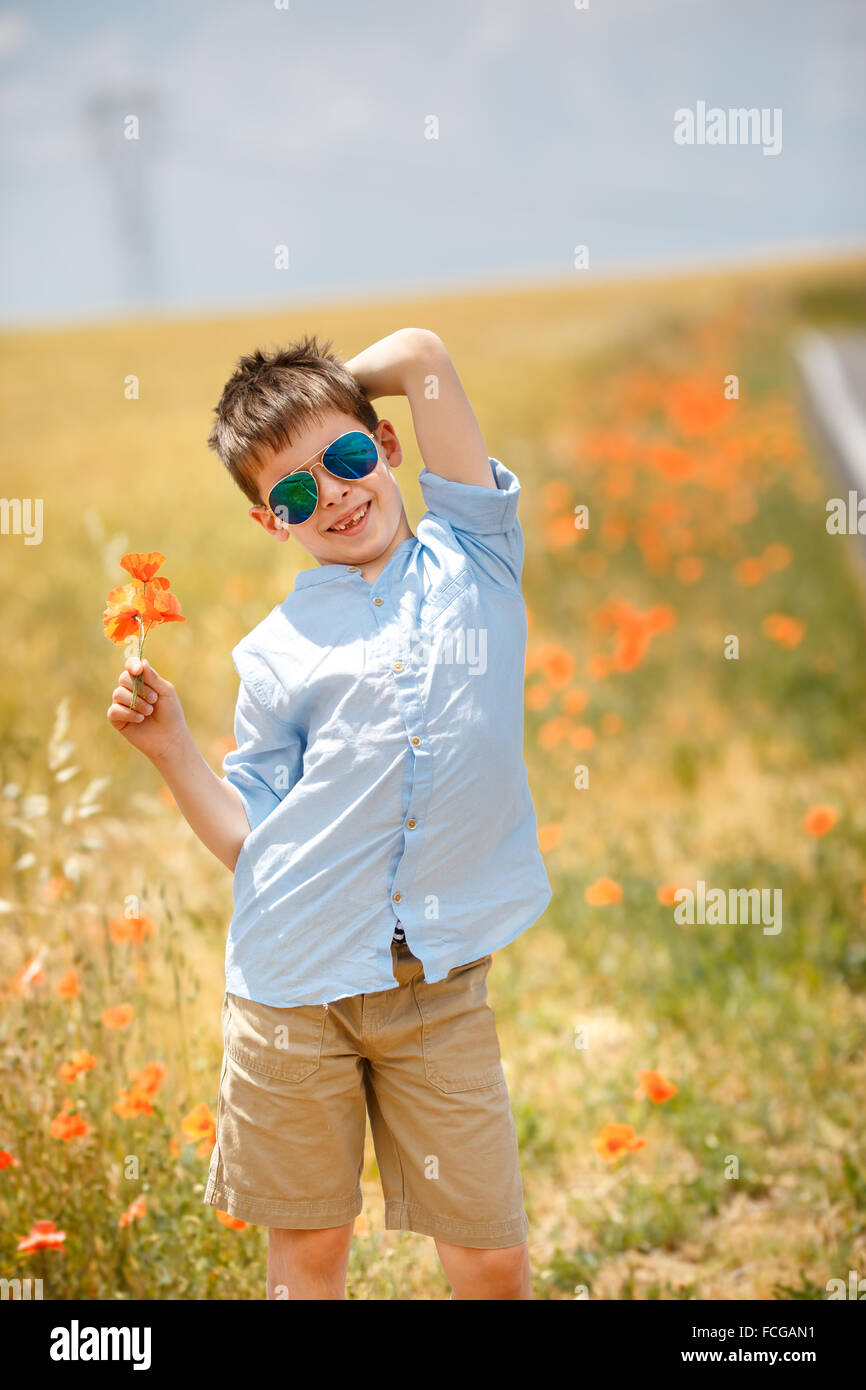 Cute smiling boy holding bouquet of poppies outdoors Stock Photo - Alamy