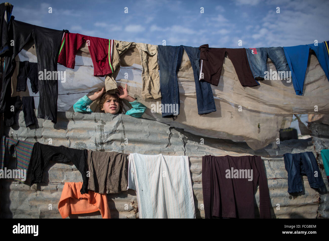 Gaza, Gaza Strip. 22nd Jan, 2016. A Palestinian girl peeks out through a hole in her family's tent in a poverty-stricken area of Beit Hanun town, in the northern Gaza Strip, on Jan 22, 2016. © Wissam Nassar/Xinhua/Alamy Live News Stock Photo