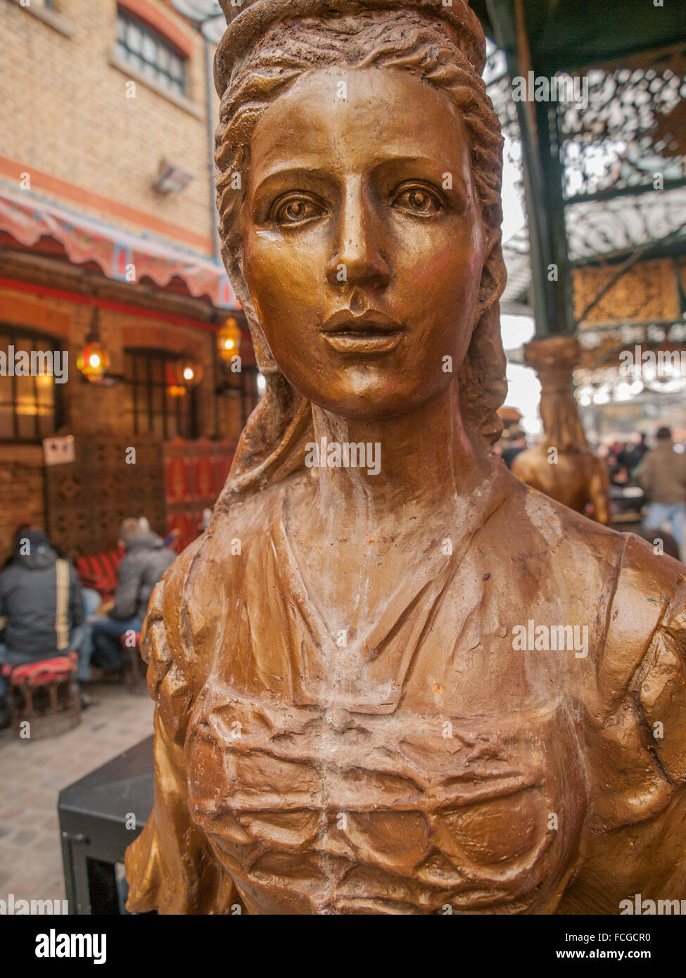 Bronze weathered statue of woman which is also a column in Camden Market, London, United Kingdom