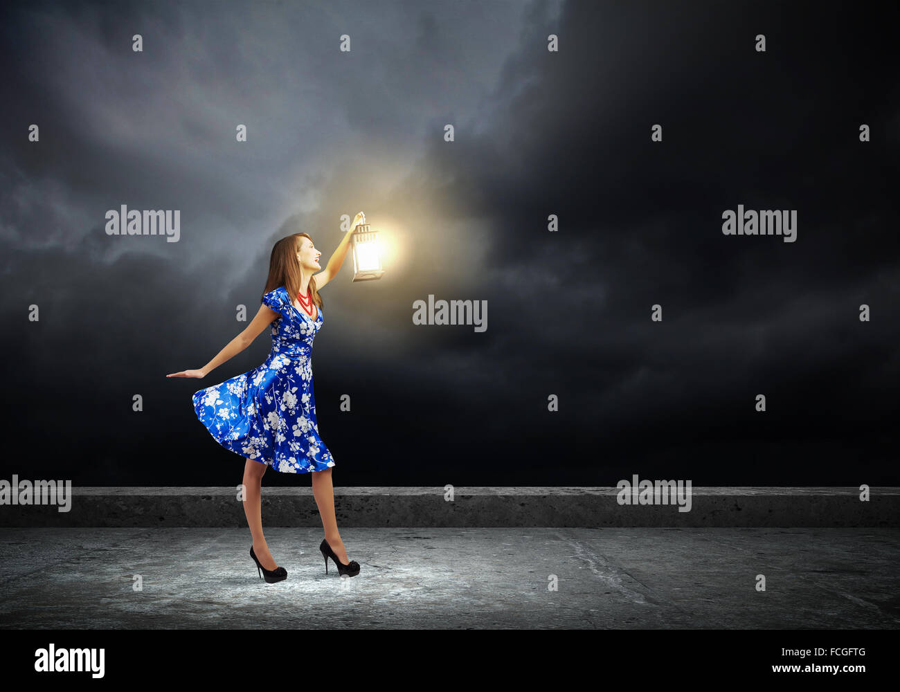 Young woman in blue dress with lantern Stock Photo - Alamy