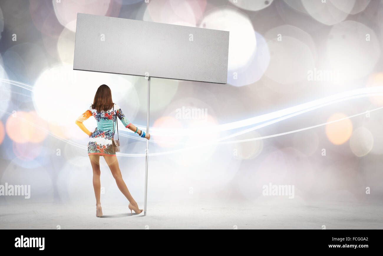 Rear view of young attractive woman with blank white banner Stock Photo ...