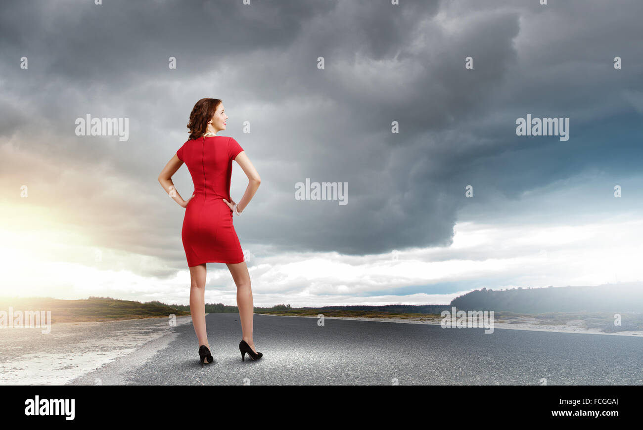 Rear view of young woman standing aside of road Stock Photo - Alamy