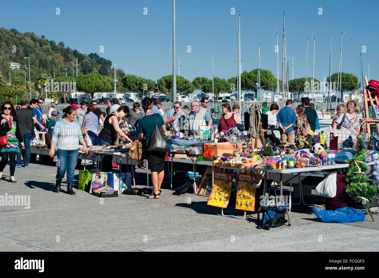 People shopping at a local market in Hondarribia marina with yachts moored in the background. Basque Country, Spain. Stock Photo