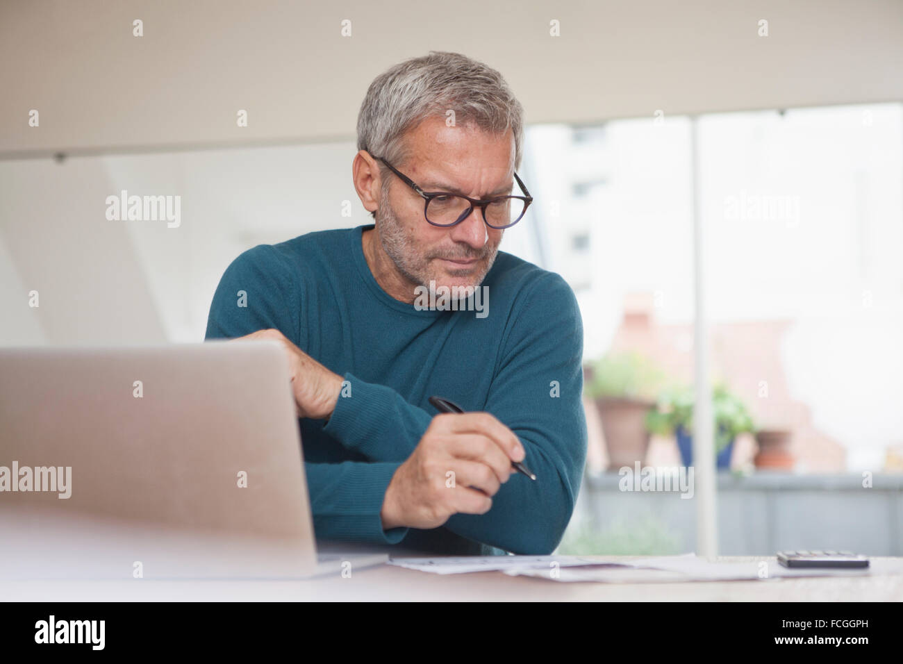 Mature man at home using laptop Stock Photo - Alamy