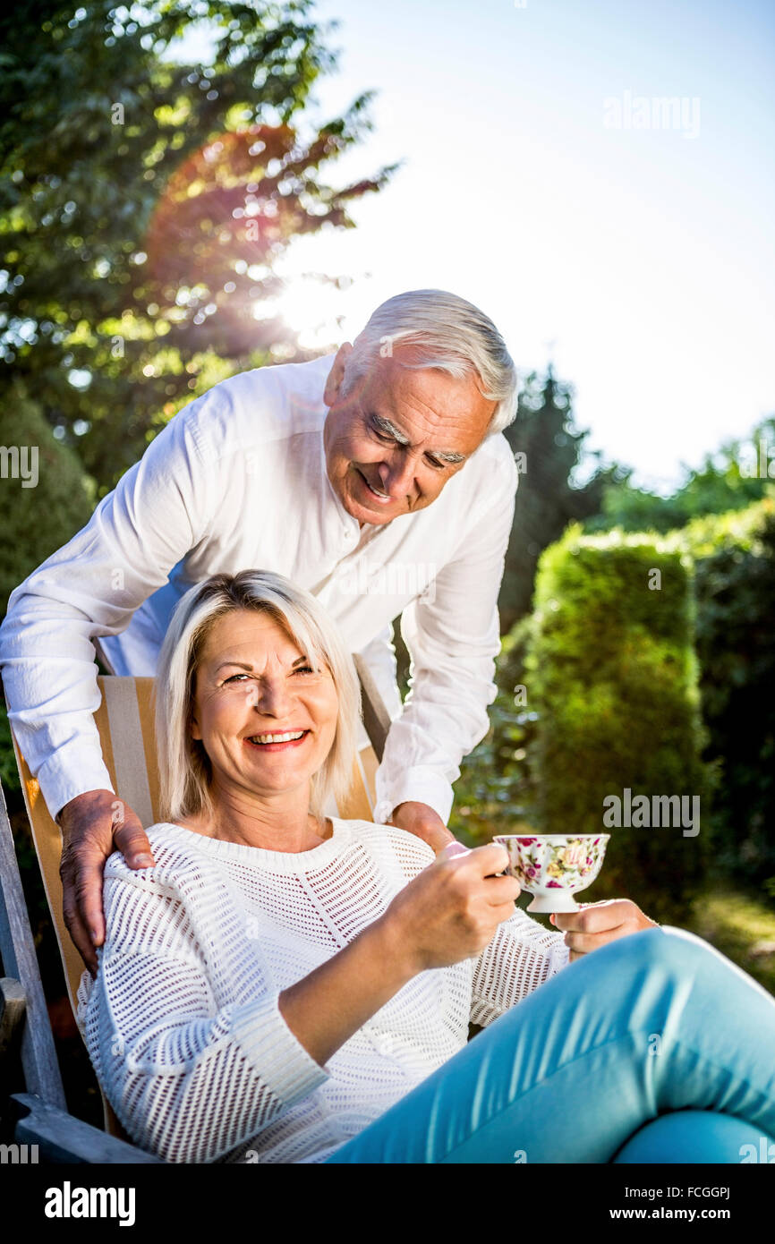 Elderly couple relaxing in garden Stock Photo - Alamy