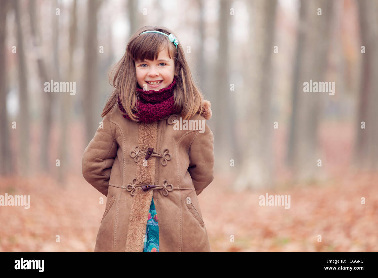 Young girl brown coat in park autum smiling Stock Photo - Alamy