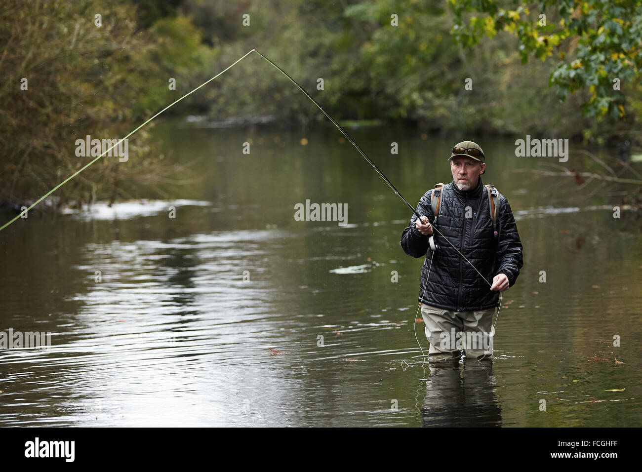 A man fly fishing in a river Stock Photo