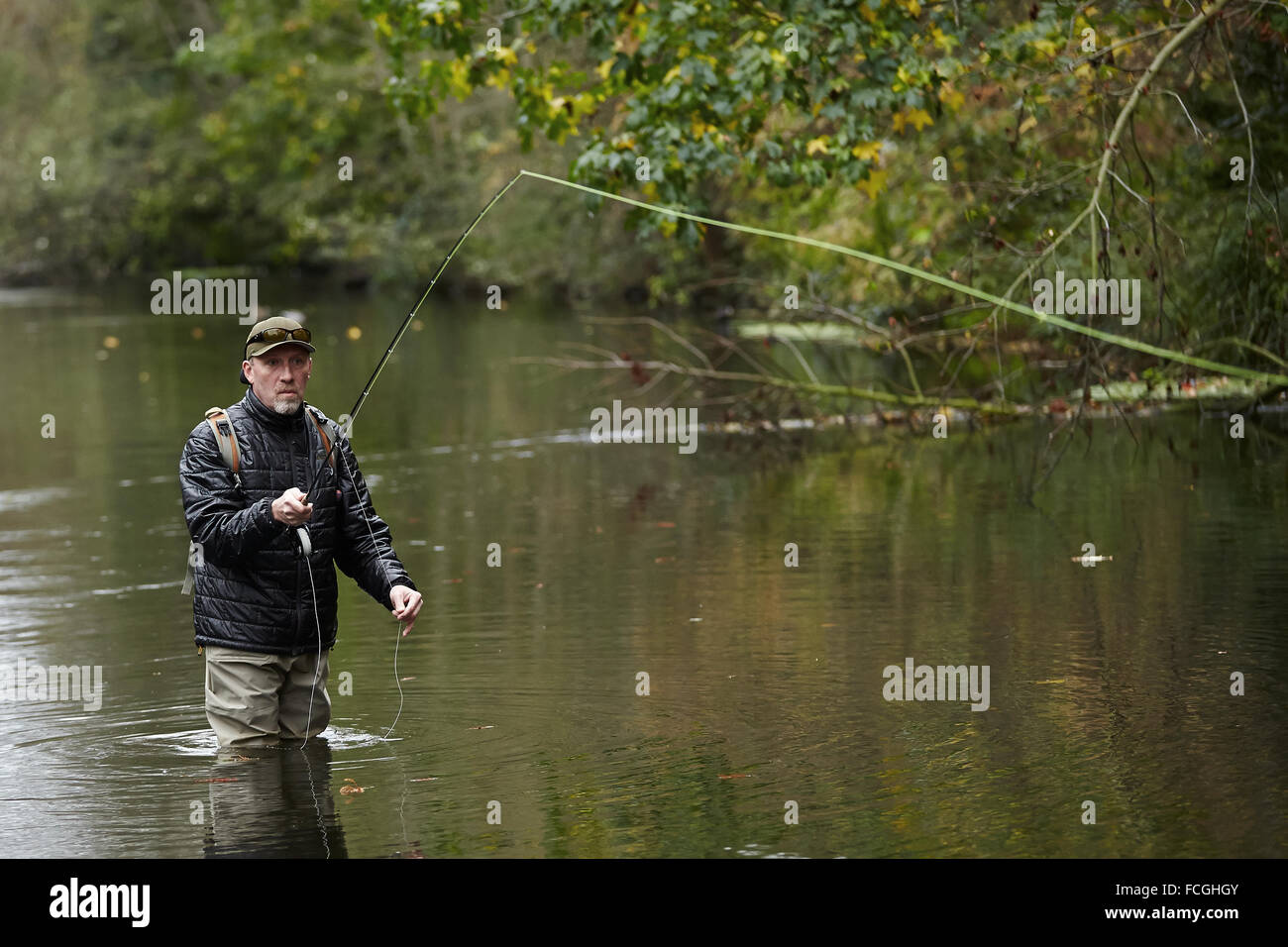 A man fly fishing in a river Stock Photo