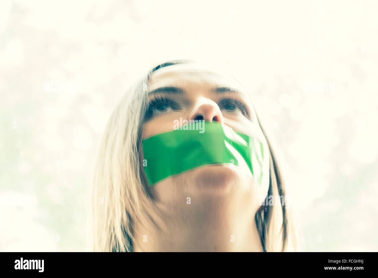 Young woman with tape over her mouth Stock Photo Alamy