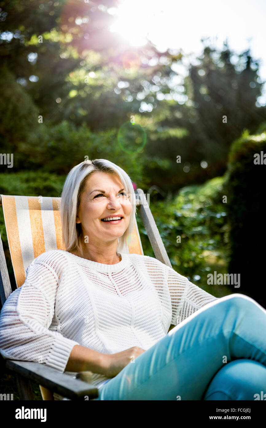 Mature woman relaxing in deckchair in garden Stock Photo - Alamy