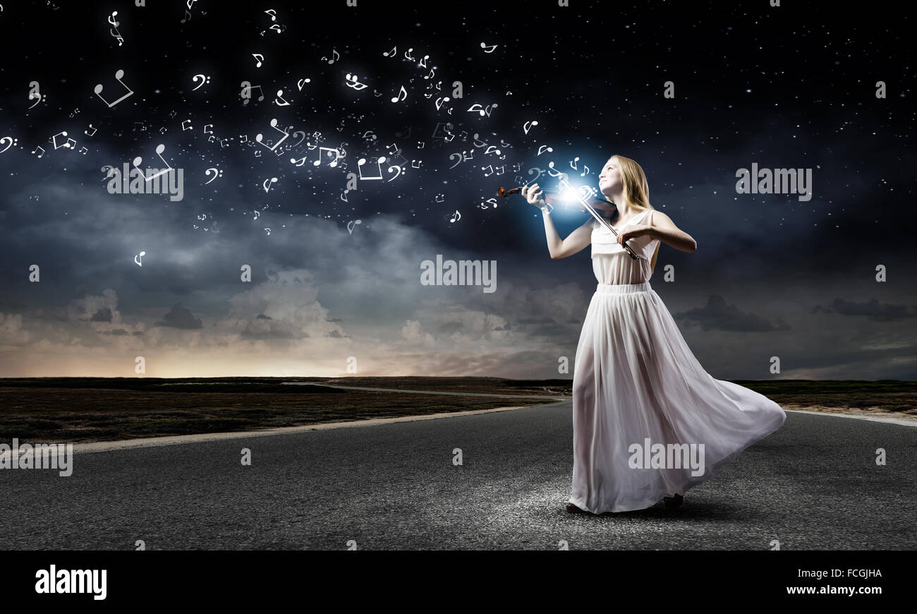 Young woman in white dress playing violin at night Stock Photo - Alamy