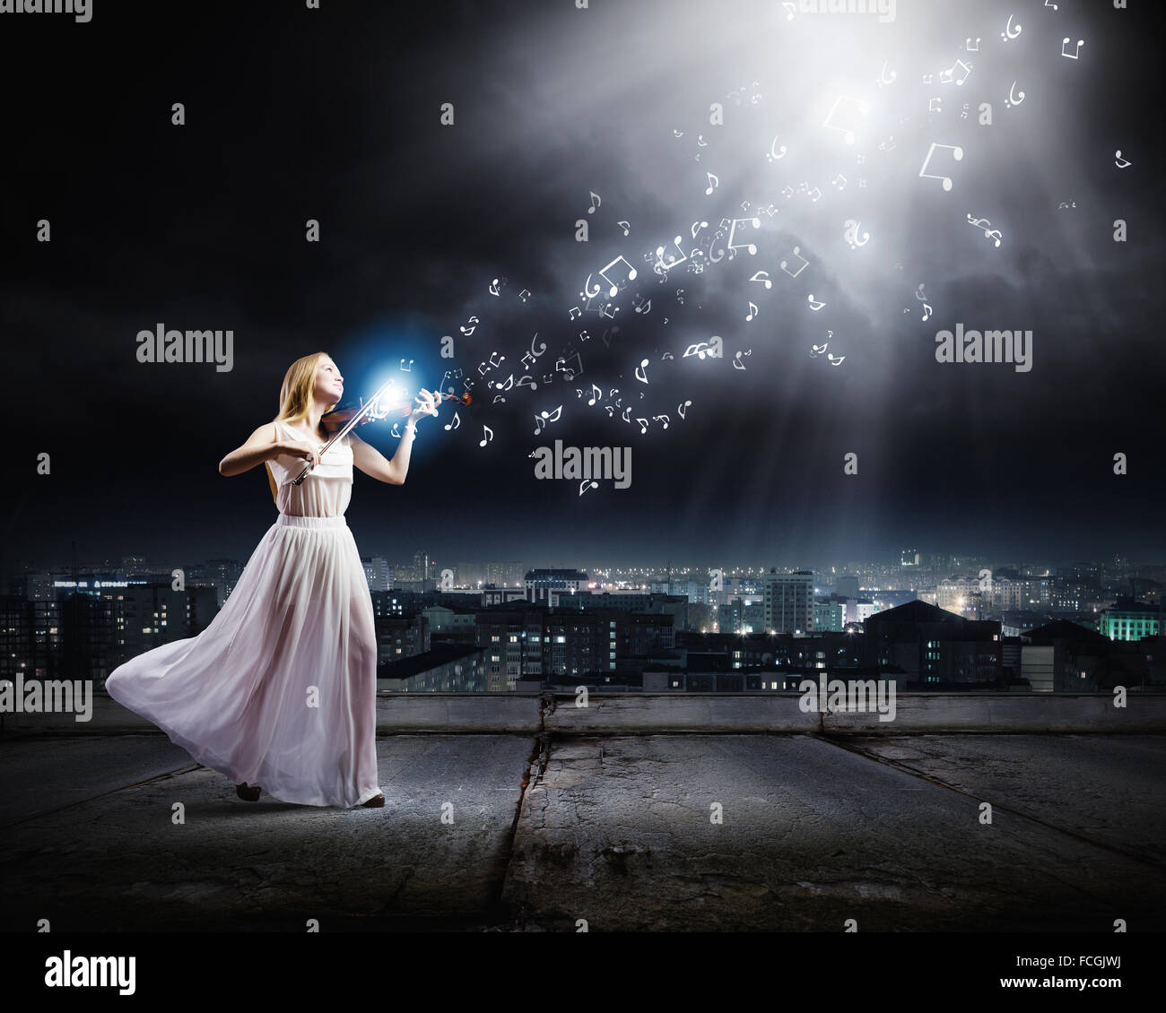 Young woman in white dress playing violin at night Stock Photo - Alamy