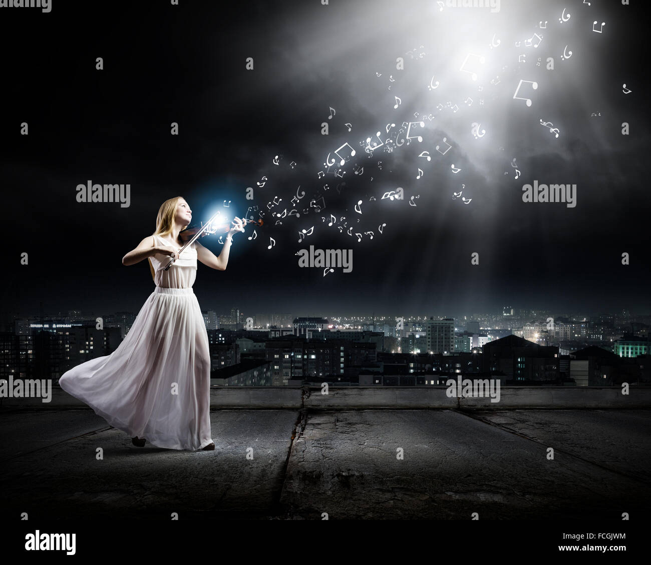Young woman in white dress playing violin at night Stock Photo - Alamy
