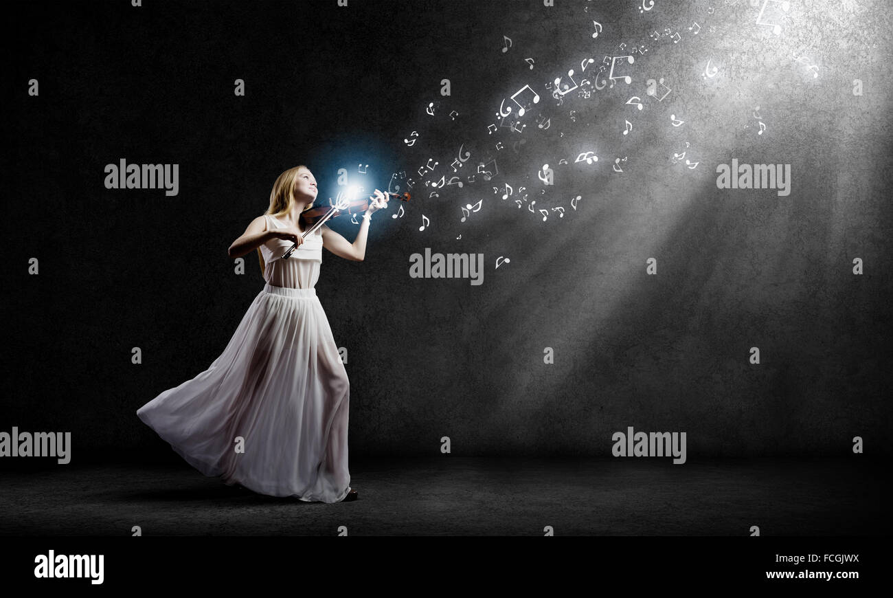 Young woman in white dress playing violin at night Stock Photo - Alamy