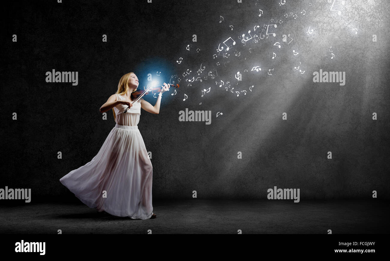 Young woman in white dress playing violin at night Stock Photo - Alamy