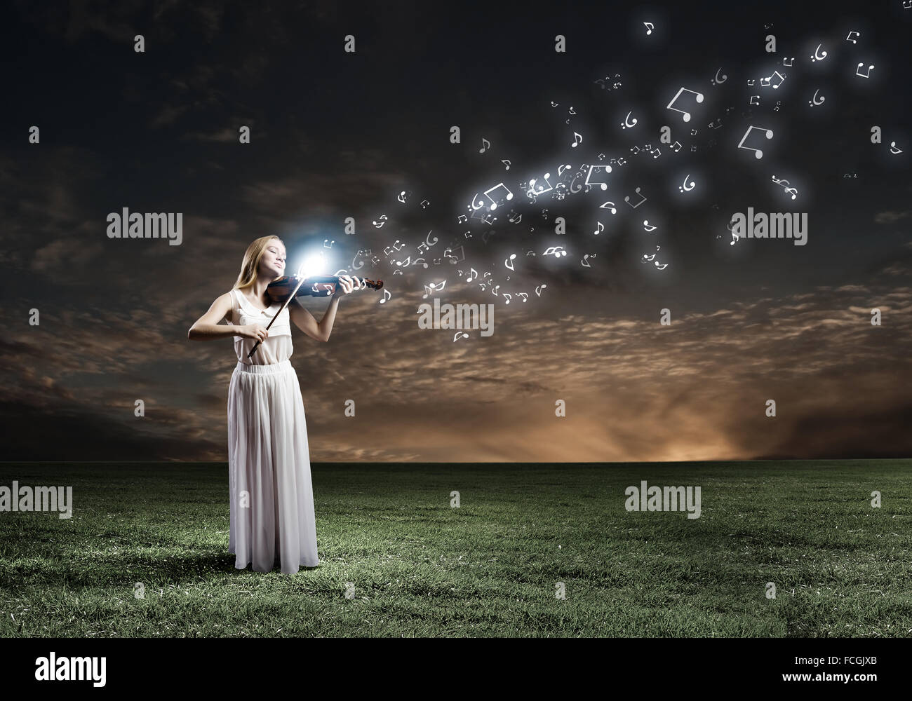 Young woman in white dress playing violin at night Stock Photo - Alamy