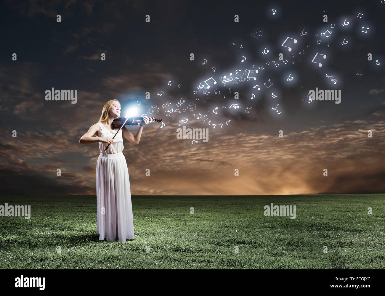 Young woman in white dress playing violin at night Stock Photo - Alamy
