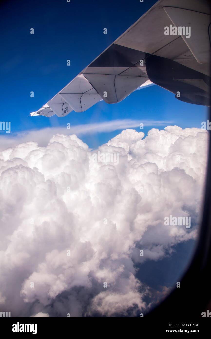 Airplane flying high above the clouds. Stock Photo