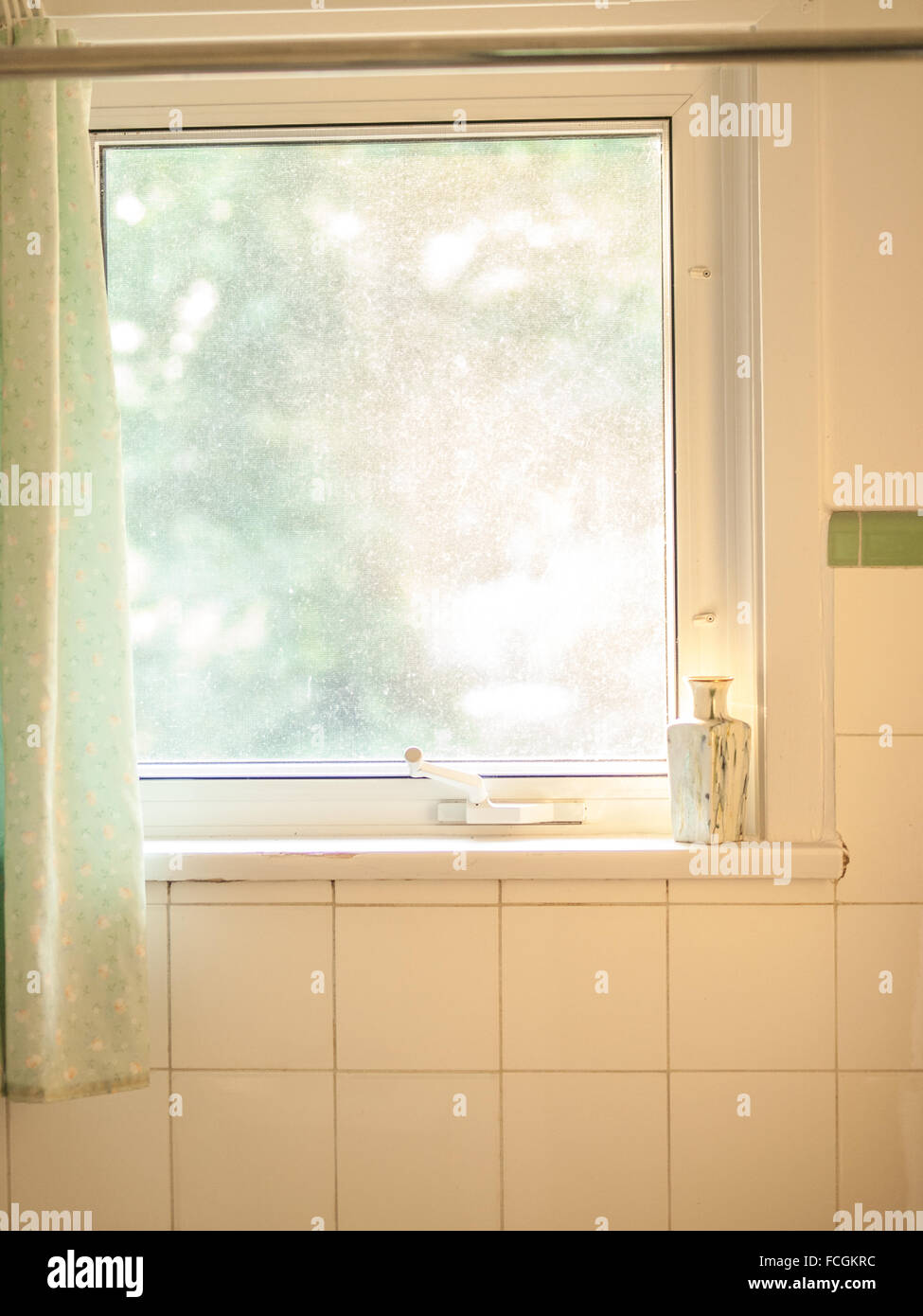 Bright single pane window surrounded by white tiles in a shower stall in a residential home. Stock Photo