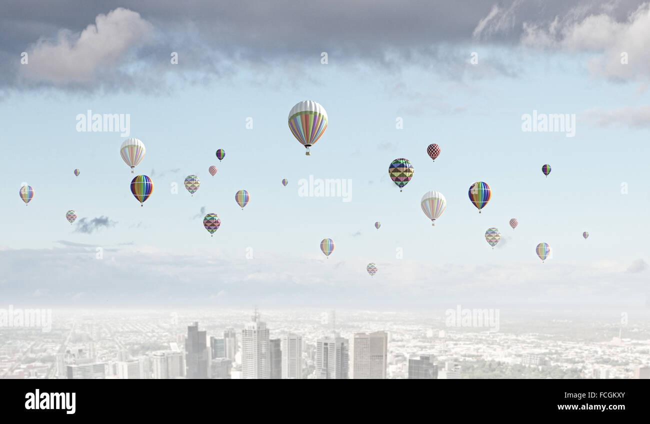 Colorful aerostats flying in clear sky above modern city Stock Photo ...