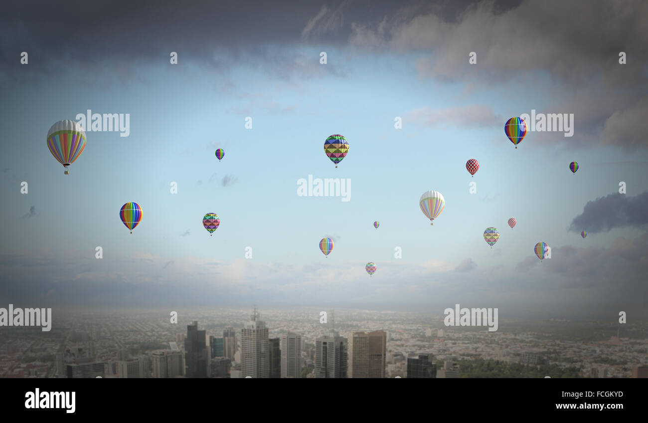 Colorful aerostats flying in clear sky above modern city Stock Photo ...