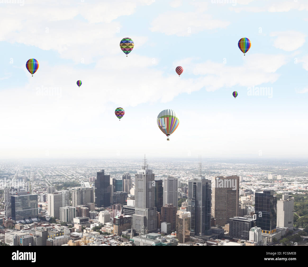 Colorful aerostats flying in clear sky above modern city Stock Photo ...