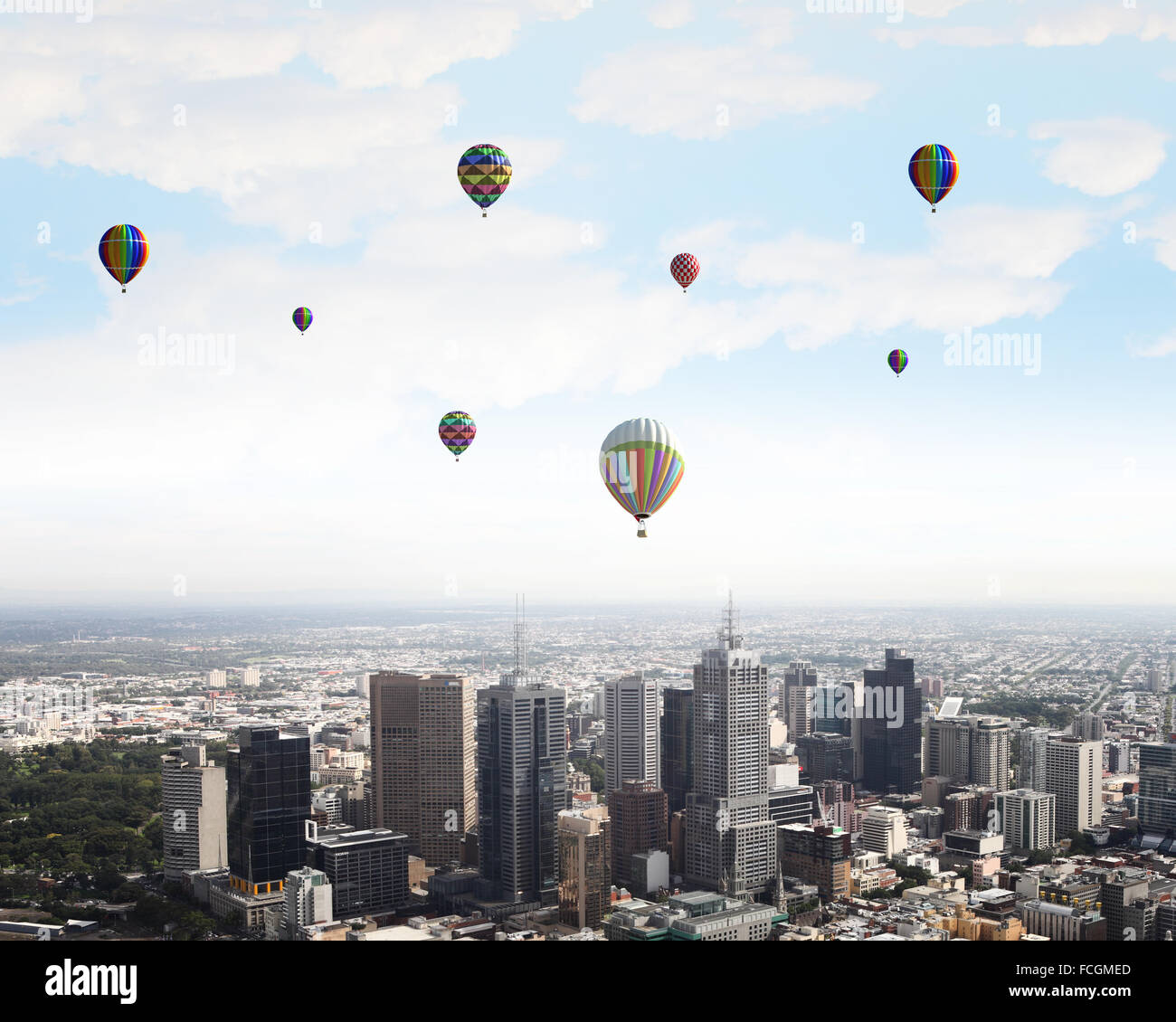 Colorful aerostats flying in clear sky above modern city Stock Photo ...