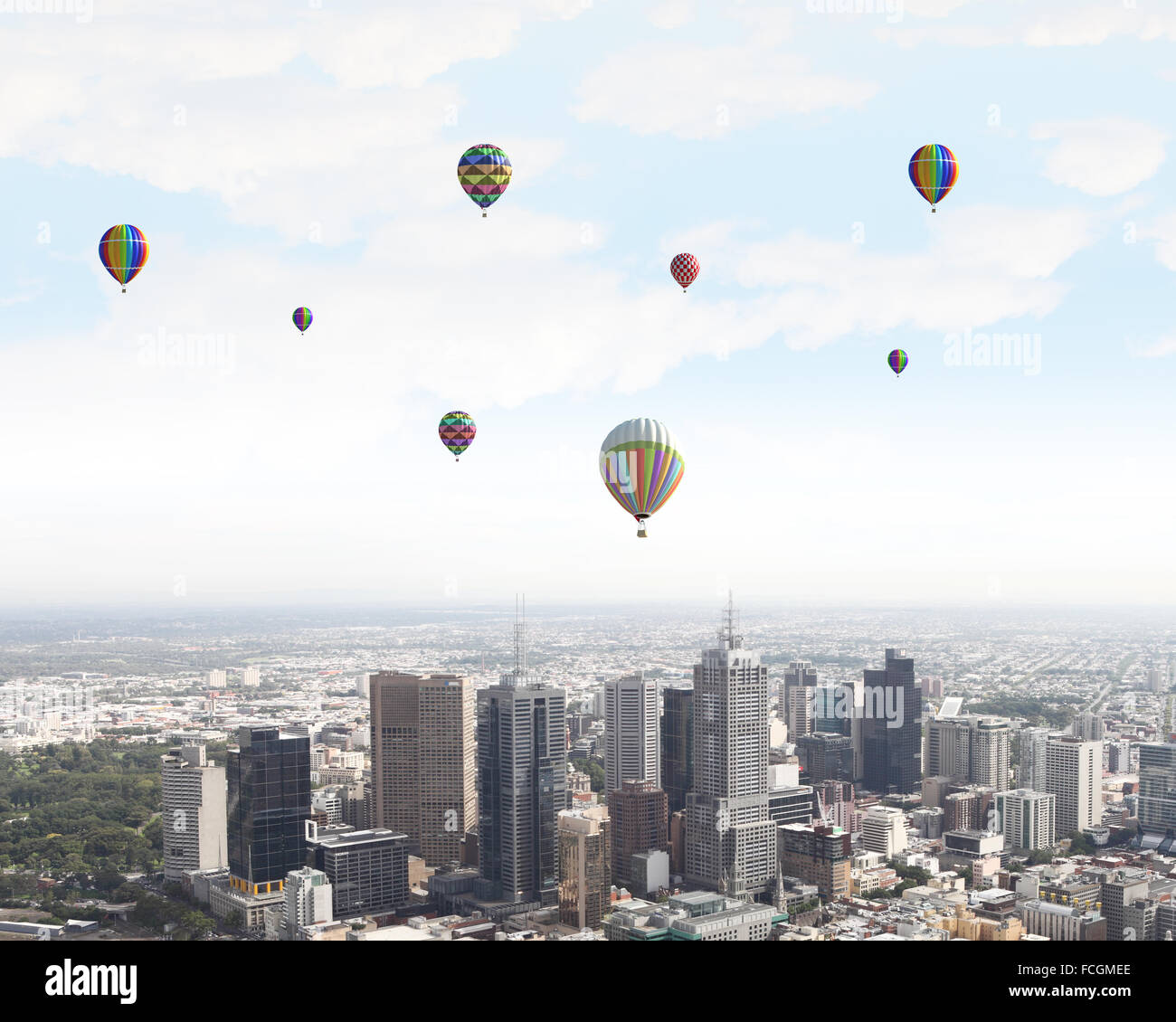 Colorful aerostats flying in clear sky above modern city Stock Photo ...