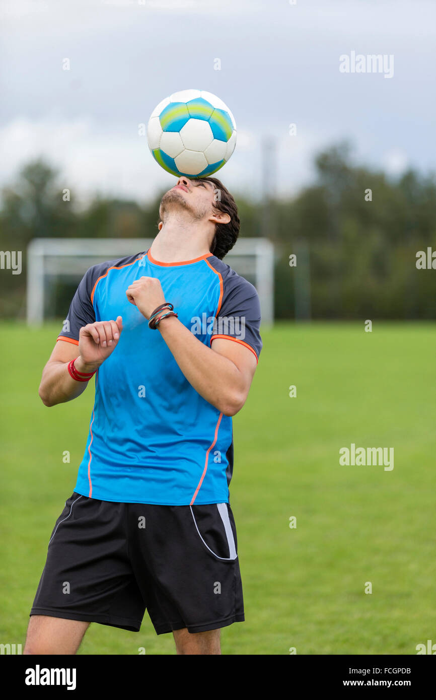 Soccer player balancing ball on head Stock Photo Alamy
