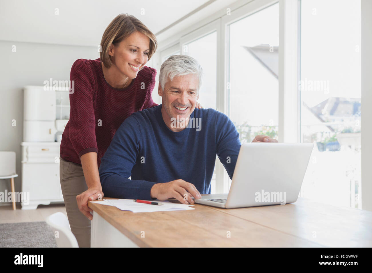 Smiling couple using laptop at home Stock Photo