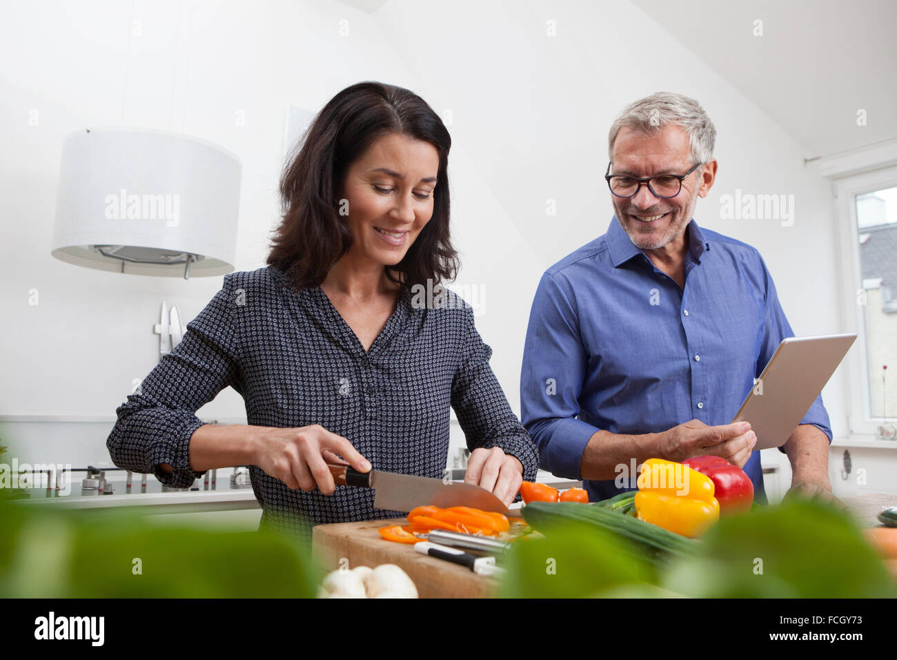 Mature couple   digital tablet cooking in kitchen Stock Photo