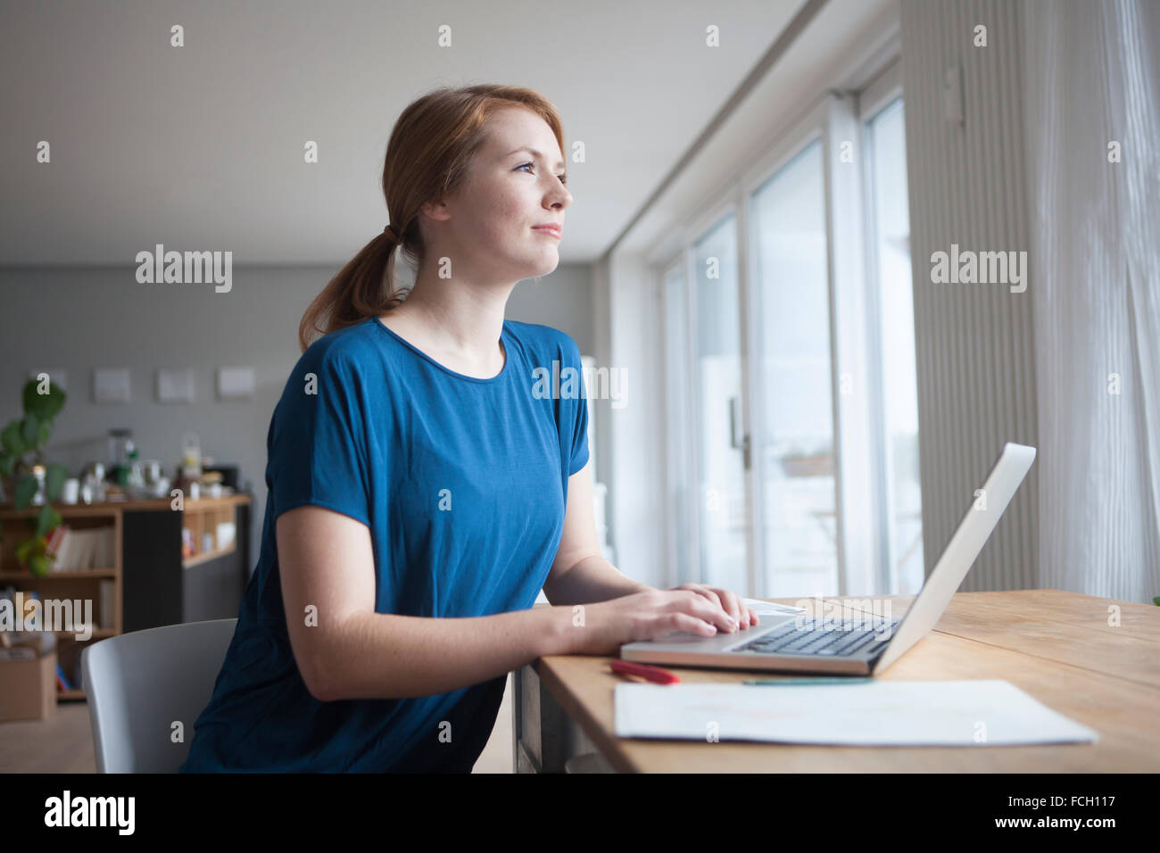 Young woman sitting at table   laptop Stock Photo