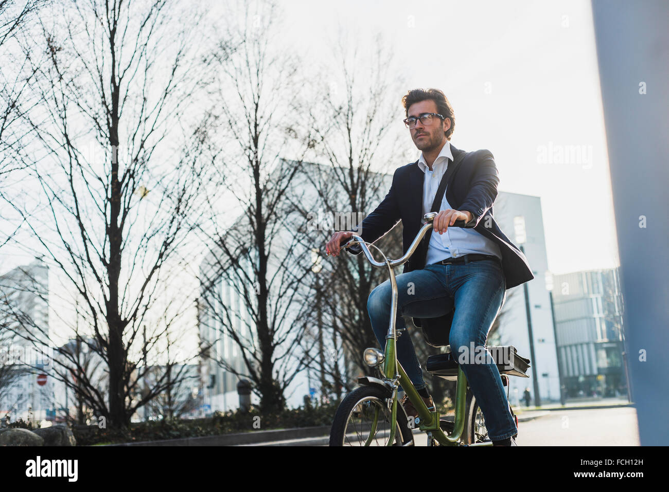 Germany Frankfurt Young businessman in the city riding bicycle Stock Photo