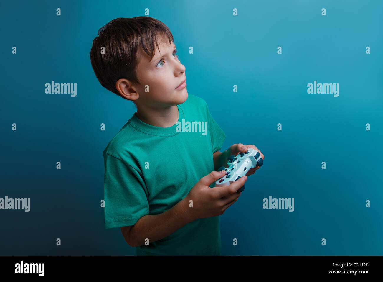 a boy of twelve European appearance holding a game joystick on a Stock Photo