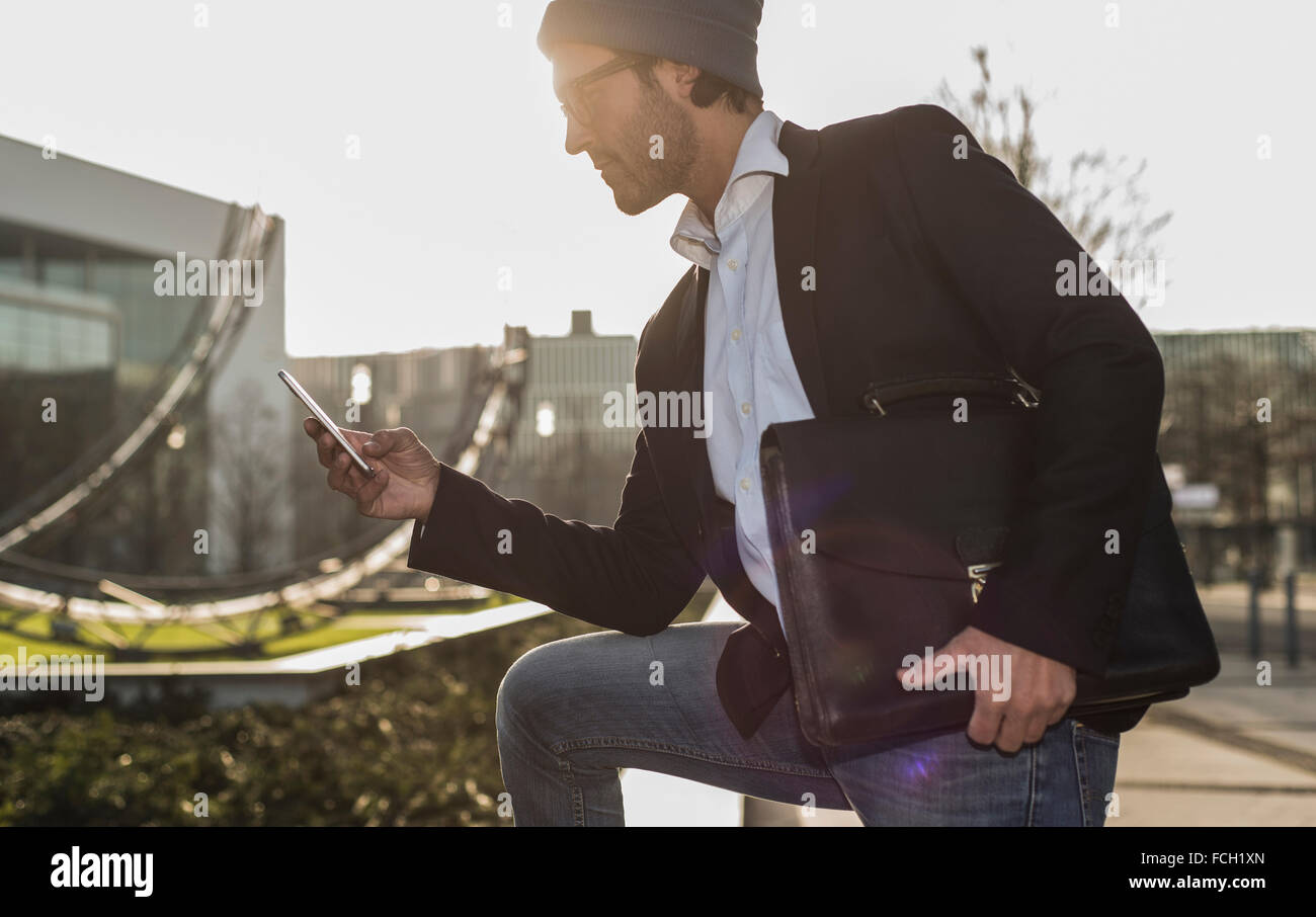 Germany Frankfurt Young businessman in the city using mobile phone Stock Photo