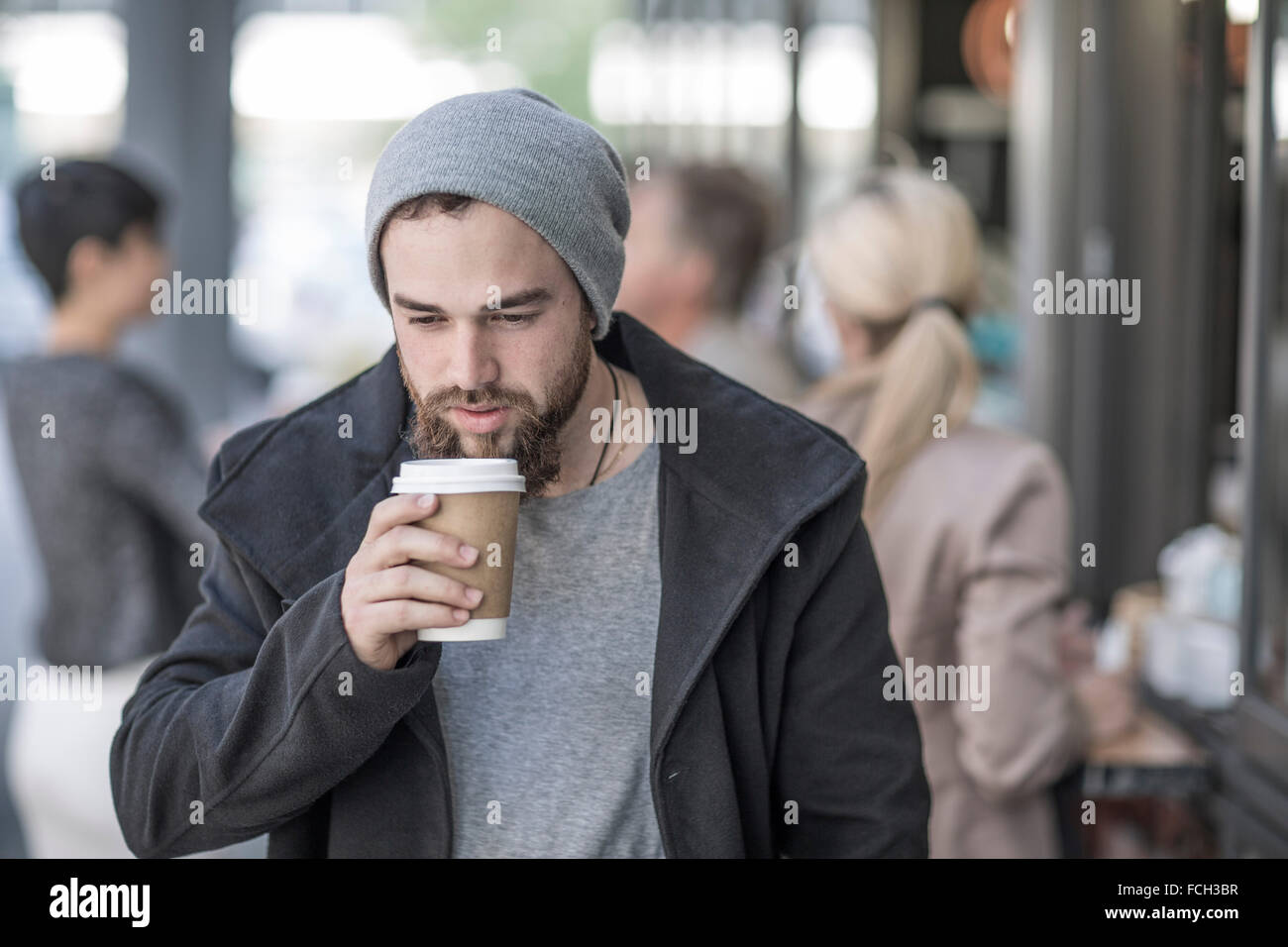 Young man drinking takeaway coffee in the city Stock Photo