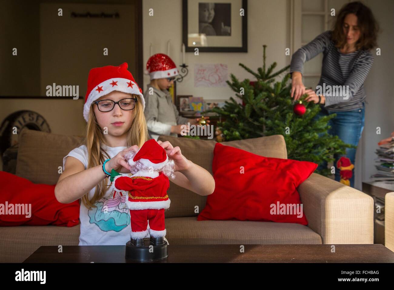 FAMILY DECORATING THE CHRISTMAS TREE Stock Photo