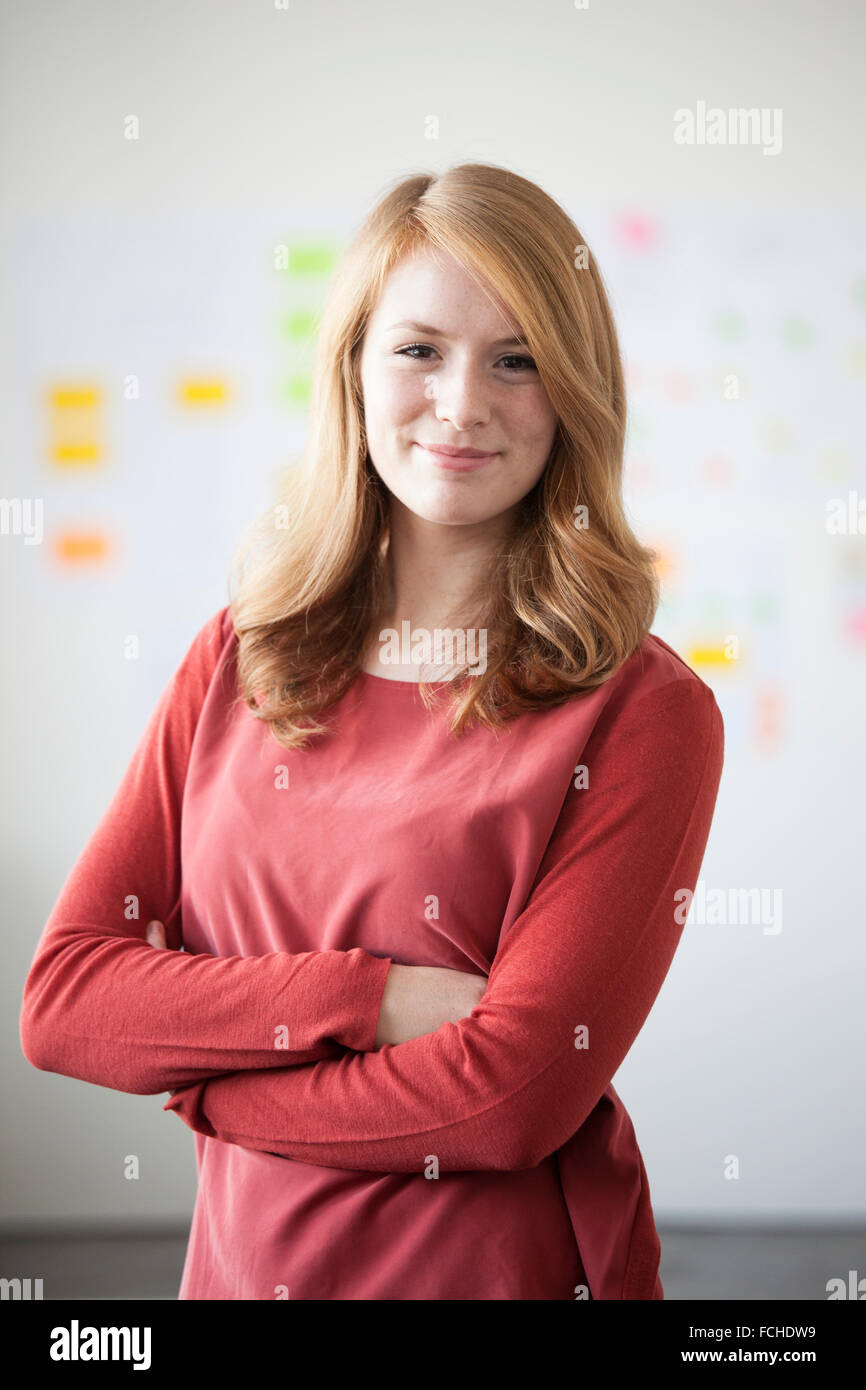 Young woman in office   arms crossed Stock Photo