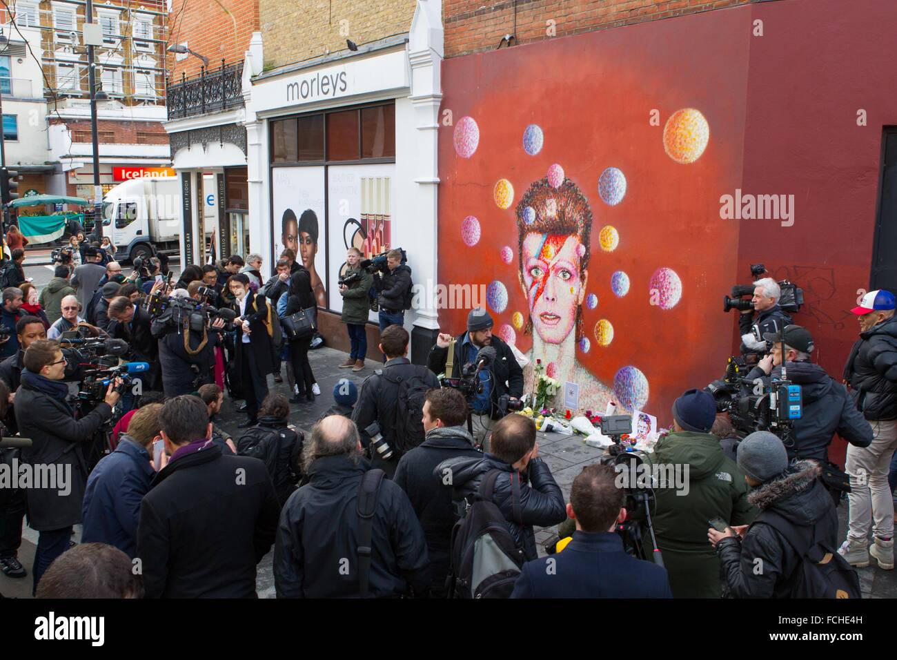 Crowds of fans and media gather at the Mural of David Bowie in the star's birthplace of Brixton. Stock Photo
