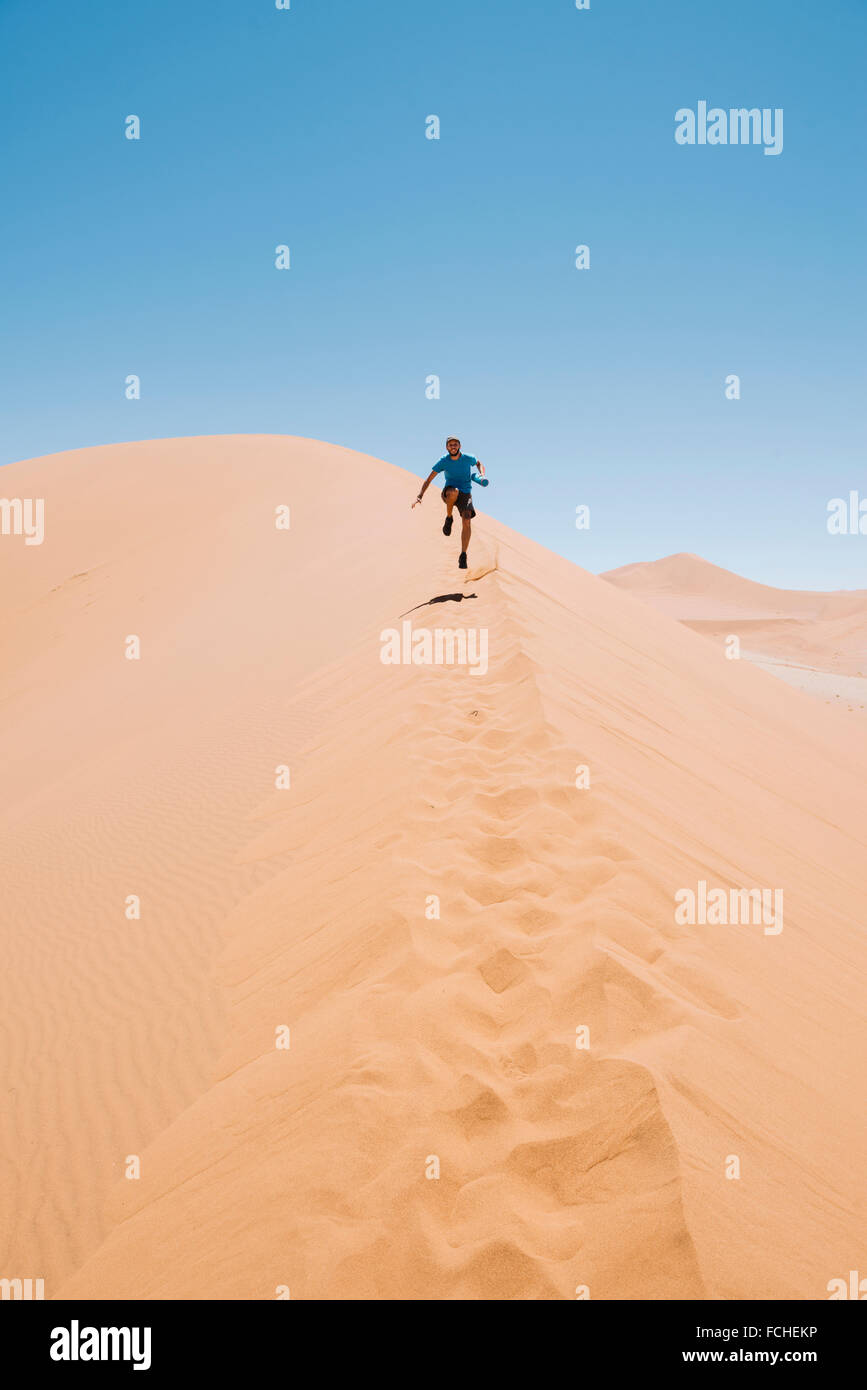 Namibia Namib Desert Sossusvlei Man running down a dune Stock Photo - Alamy