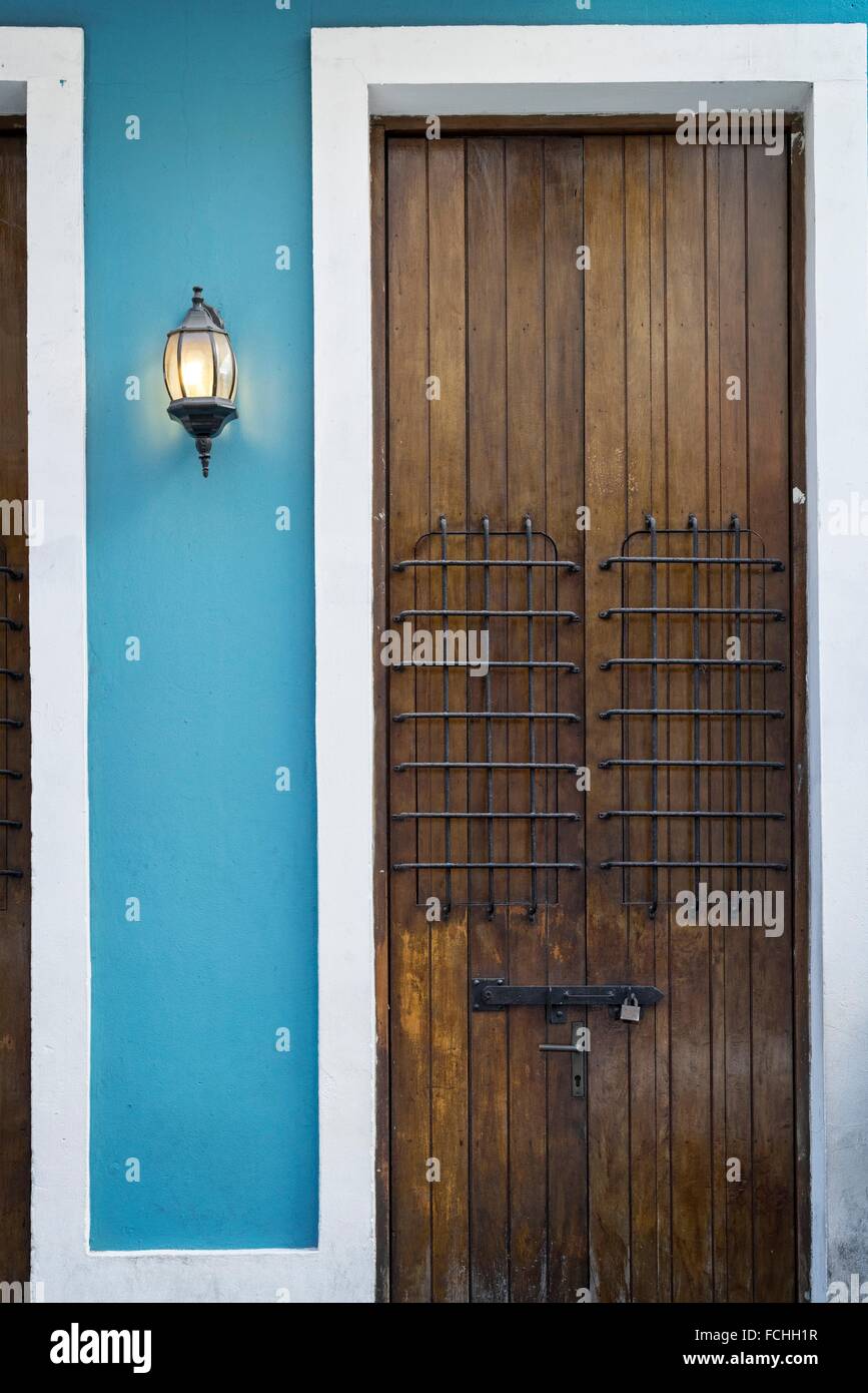 Close up of a closed, wood-paneled double door, locked. Light on. Old Town, San Juan, Puerto Rico. Stock Photo